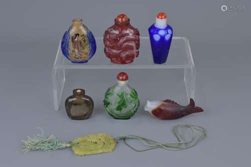 A group of six Chinese carved glass snuff bottles and jade pendant