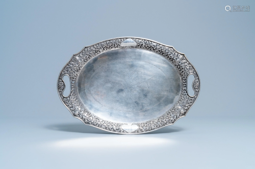 An oval silver tray with incised floral design,