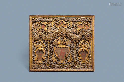A Chinese carved and gilt wooden panel with red …