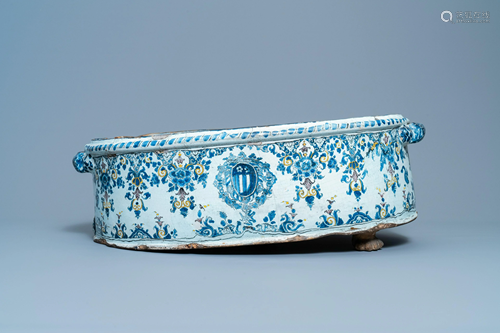 A large oval polychrome French faience armorial basin,