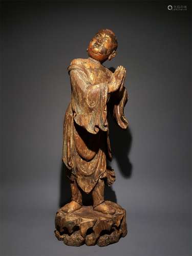 A YUAN DYNASTY WOOD CARVED GOLD LACQUER BOY