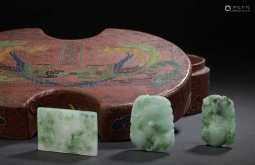 Three jadeite pendants and their lacquered wooden …