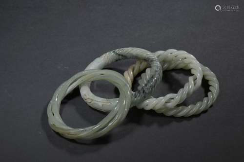 Four celadon jade bracelets China Twisted, one dec…