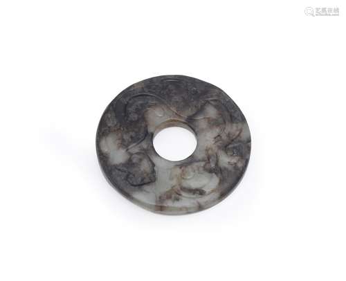 A Chinese pale celadon and brown jade bi disc