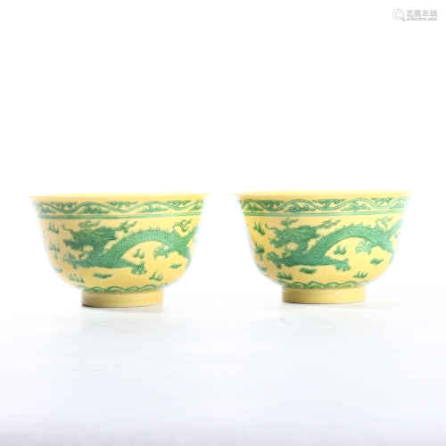 A pair of bowls decorated with yellow glaze and green dragon and longevity characters