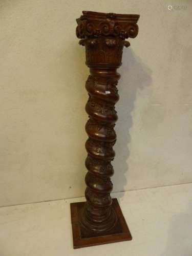 A twisted column in dark oak carved with branches …