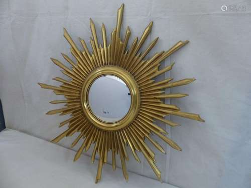 A golden wooden sun mirror.