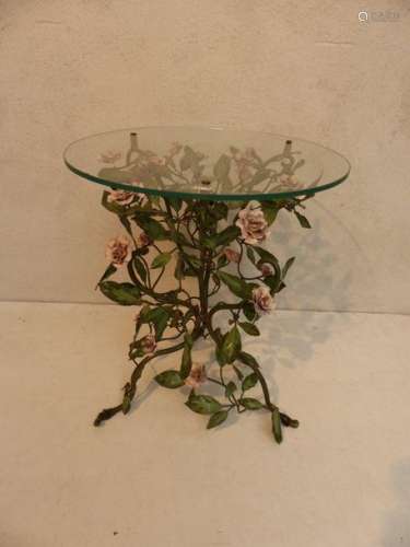Small painted iron table with plant decoration.