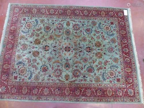 Large woollen rug with floral decoration on a pale…