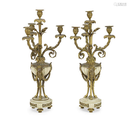 A pair of late 19th century French gilt bronze and white marble four light garniture candelabra in the Louis XVI style