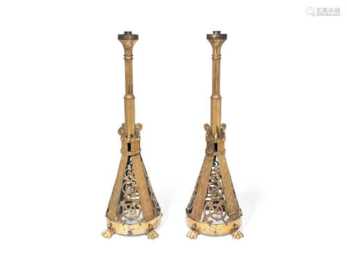 A pair of late 19th century brass floorstanding altar candlesticks in the Celtic Revival taste