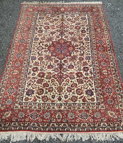 An Esfahan carpet, West Persia, the ivory field with a madder floral medallion, scrolling vines,