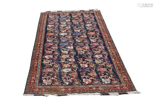 A North West Persian carpet, the indigo field with rows of polychrome flowering branches, within a