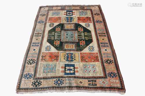 A Turkish carpet, the ivory field with a central green octagonal medallion with hooked guls.