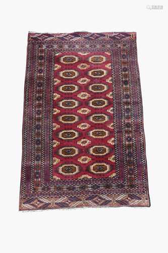 A Pakistan rug, the madderfield with eight rows of two octagonal. medallions and further secondary