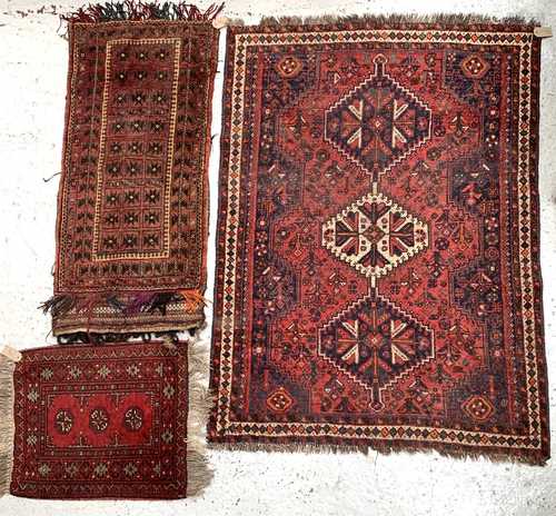 A Shiraz rug, South West Persia, madder field with a triple linked polychrome medallion within