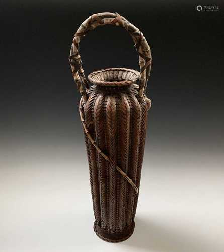 A Japanese bamboo and wicker fish basket, with entwined handle and fluted tapering body, height