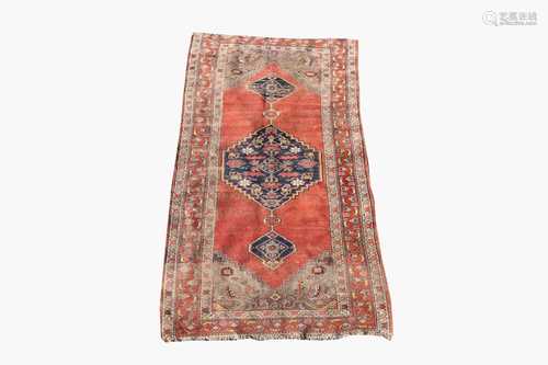 A Kurdish rug, the madder field with an indigo pole medallion with leaves and flowerheads within a