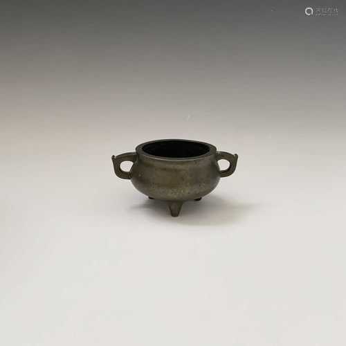 A Chinese bronze twin-handled censer, 19th century, seal mark to base, height 5.5cm, width 11.5cm.