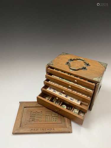 A Chinese Mahjong set, early-mid 20th century, the carved wood cabinet surmounted by a twin