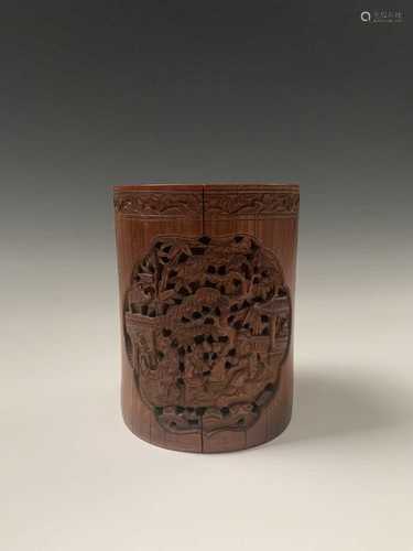 A Chinese bamboo brush pot, 19th century, with rows of calligraphy, carved with trees and pagodas