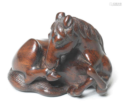 A wood netsuke of a seated horse Early 19th century