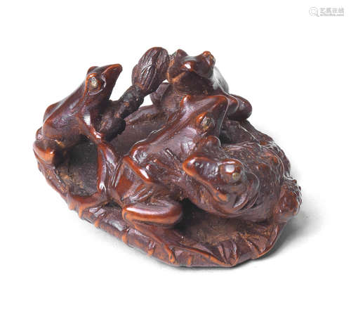 A wood netsuke of frogs and a toad on a lotus leaf By Seimin, 19th century