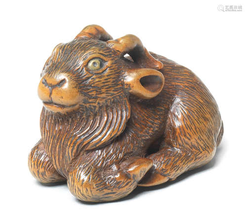 A wood netsuke of a recumbent goat By Tanaka Minko (1735-1816), Tsu, Ise Province, late 18th century