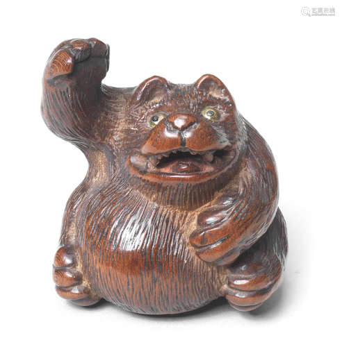 A wood netsuke of a tanuki By Tanaka Minko (1735-1816), Tsu, late 18th century