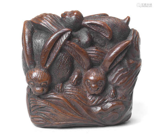 A wood netsuke of rabbits on a rock Early 19th century