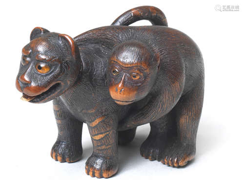 A wood netsuke of a monkey and toy tiger By Chikusai, Edo, late 19th century