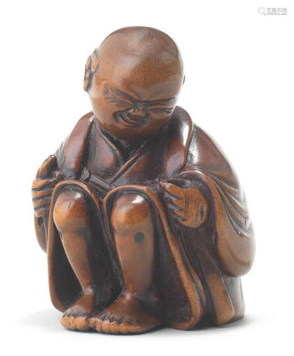 A wood netsuke of a man applying moxa Attributed to Miwa, late 18th/early 19th century