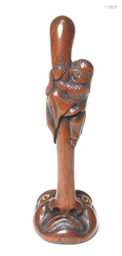 A wood netsuke of Okame on a long-nosed tengu mask Late 19th century