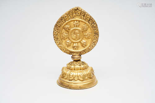 A gilt copper repoussé dharma chakara symbolic offering  Tibet or Bhutan, 18th/ 19th century