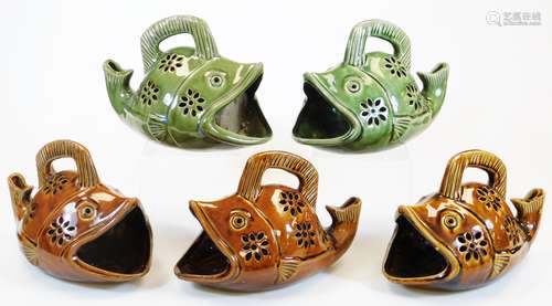 Five various pottery fish shaped containers, each with opening to the tail and mouth with part