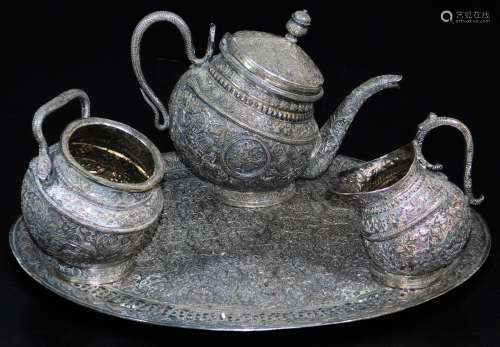 An early 20thC Indian four piece service, comprising shaped tea pot, sugar bowl, jug on an oval