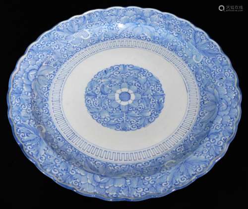 A Japanese blue and white porcelain charger, of floral form, centred with a floral rosette, the