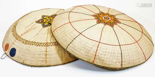 Two Vietnamese style Non La wide brim hats, each of circular form with wicker style centres, the