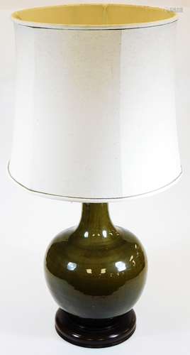 A Chinese porcelain lamp base, of bulbous form with trumpet stem, crackle glazed on a wooden