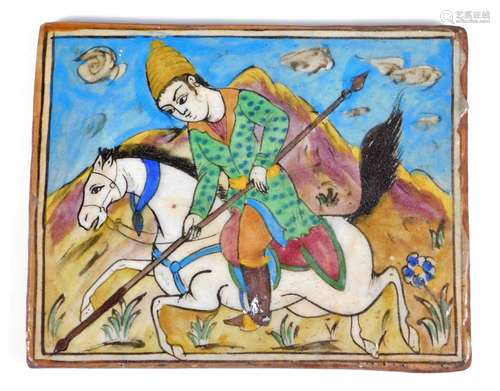 A large 18thC style Persian tile, formed as a figure on horse back holding a spear, with mountains