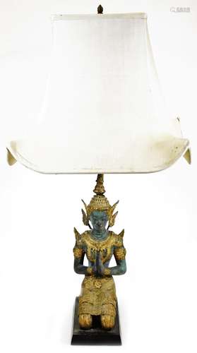 An Thai table lamp formed as a kneeling figure, in metal with elaborate head dress and clothing,