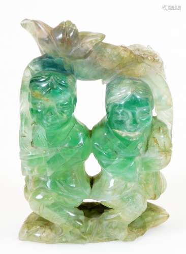 A heavily carved green quartz sculpture, formed as two figures in an arbour, on shaped base, 12cm
