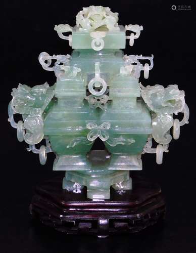 A Chinese green quartz style vase, with four central openings flanked by carved handles with an