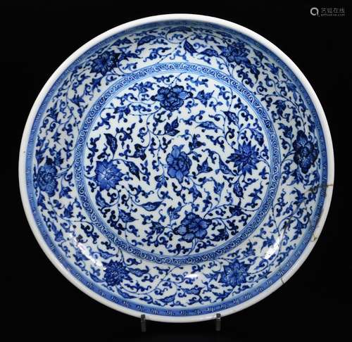 A Chinese blue and white porcelain circular plate, decorated with a central panel of scrolling