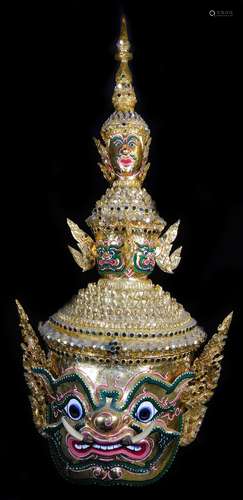 A Thai face mask, heavily decorated with mirrored glass sections set with tusks , fierce facial