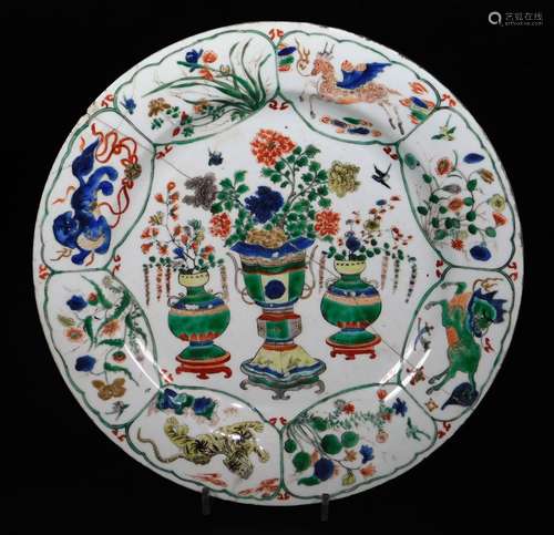 A Chinese porcelain famille vert plate, decorated with three central vases containing flowers, the