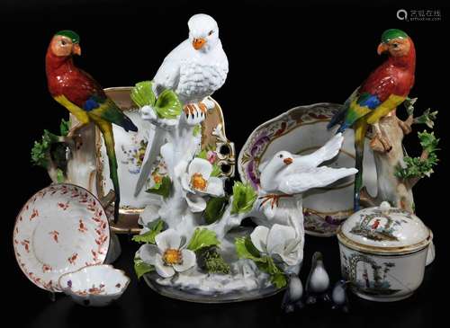 A pair of 20thC Dresden porcelain parrot figures, each polychrome decorated on tree bow bases,