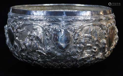 An early 20thC Indian ceremonial bowl, heavily repousse decorated with figures scrolls and