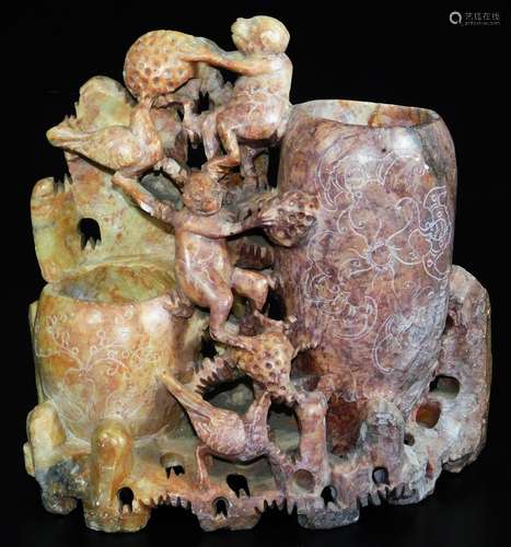 A carved Chinese soapstone figure group of monkeys and birds, with double vase opening on a shaped