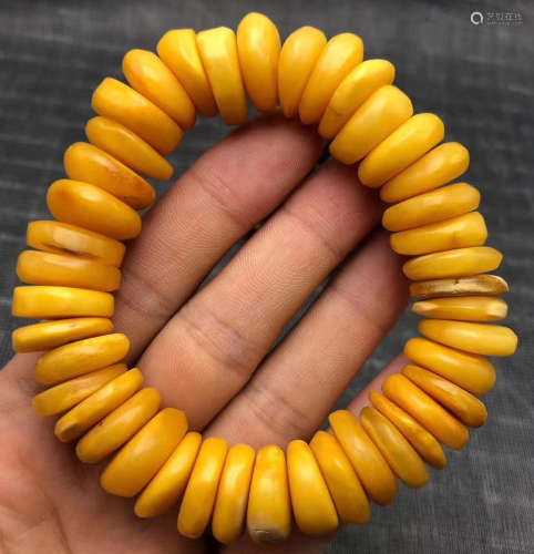 A BEESWAX CARVED BEAD STRING BRACELET